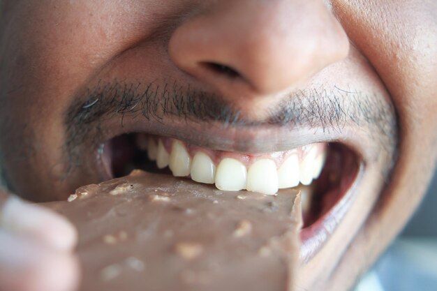 Foto joven comiendo chocolate negro de cerca