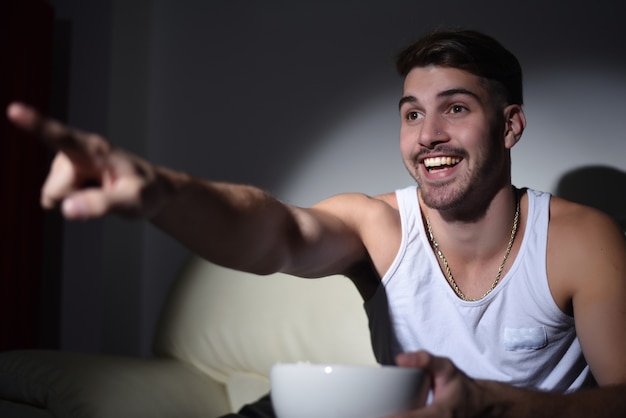 Joven comiendo palomitas de maíz y viendo películas