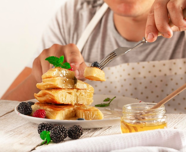 joven comiendo panqueques con fruta