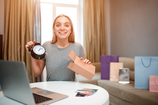 Foto el joven comprador sorprendido está desempacando un paquete con un reloj de moda