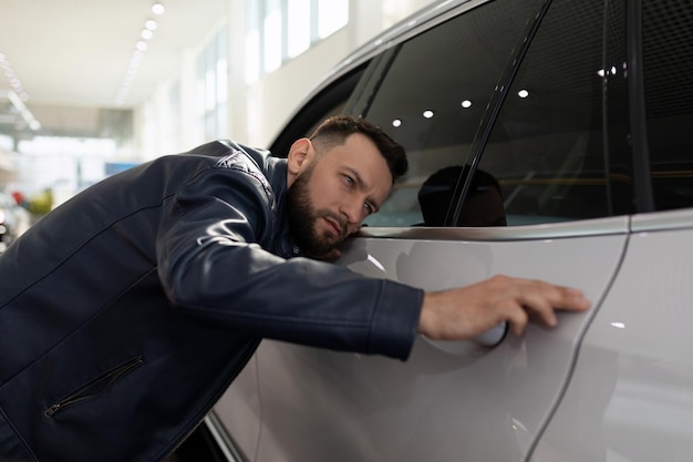 Joven en un concesionario de automóviles inspeccionando un nuevo SUV