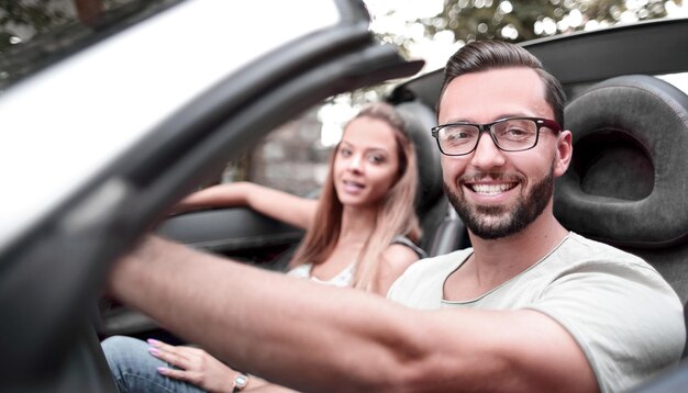 Joven conduciendo un coche descapotable