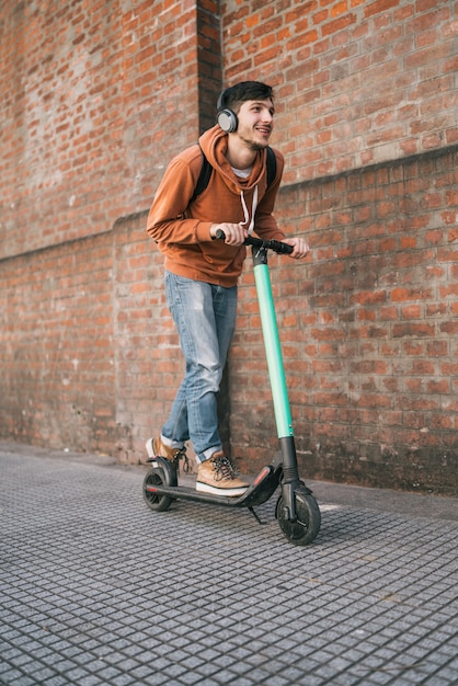 Joven conduciendo scooter eléctrico.