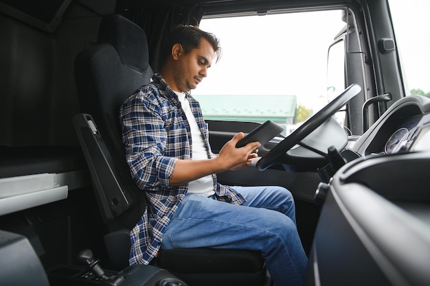 Un joven conductor de camión indio se sienta detrás del volante