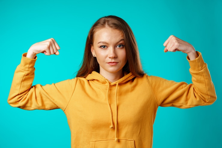 Foto joven confiada mostrando sus fuertes brazos