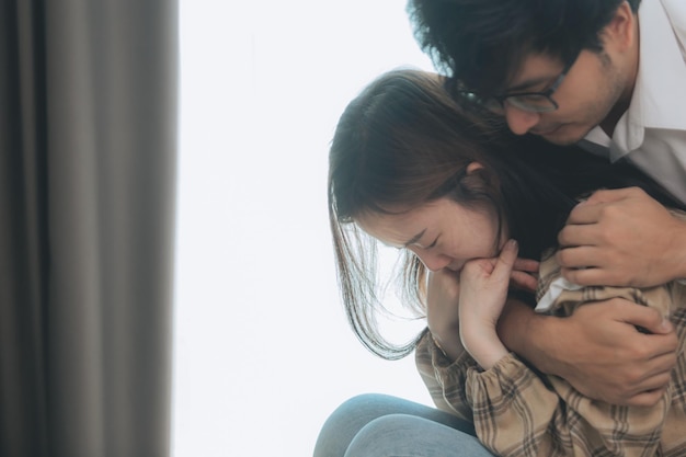 Joven consolando y apoyando a una mujer triste que está en serios problemas en casa