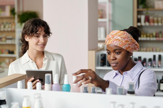 Joven consumidora afroamericana que elige un producto de belleza