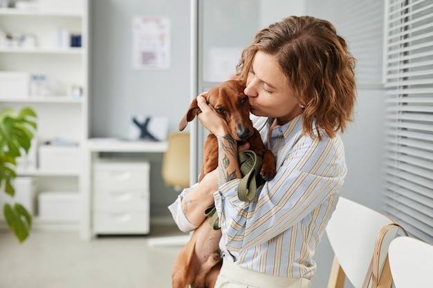 Foto joven contemporánea dando un beso a su linda mascota