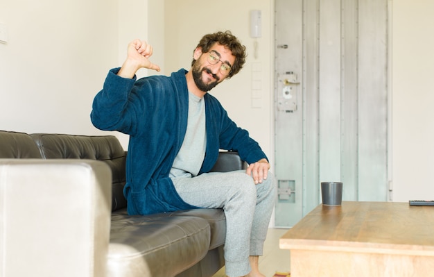 Foto joven cool sentado en un sofá en el salón viendo la televisión