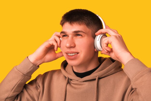 Joven con corchetes de dientes quiere escuchar música y se pone auriculares