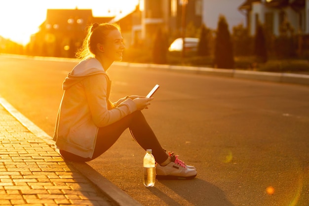 Foto joven corredora, atleta durante el jogging en la calle de la ciudad bajo el sol.