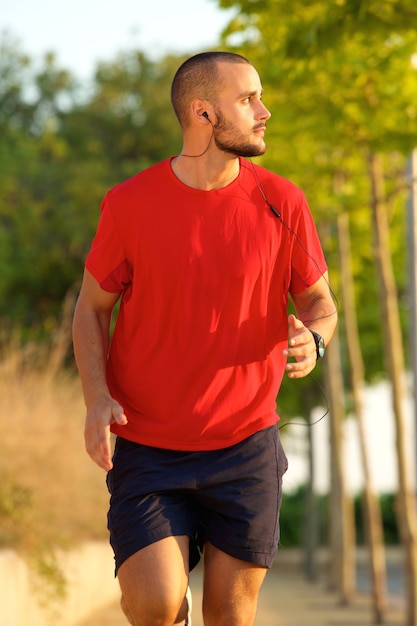 Joven corriendo con auriculares fuera