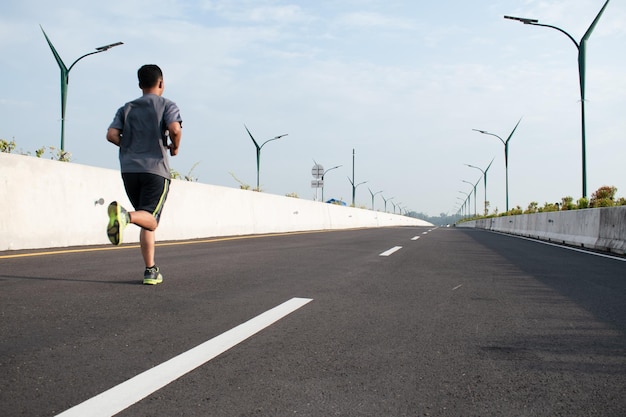 Foto joven corriendo corriendo en la carretera corredor de hombre en la calle corriendo para hacer ejercicio