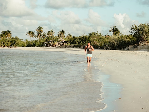 Joven corriendo a lo largo de la costa del Océano Atlántico