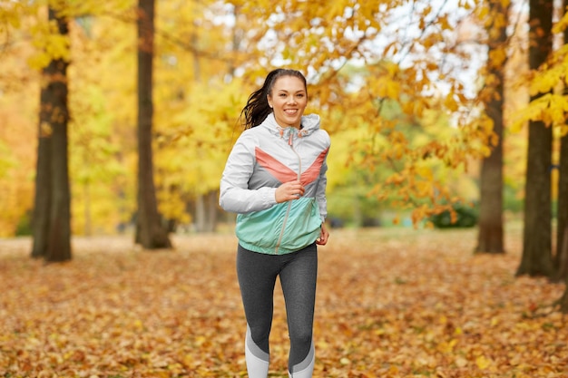 joven corriendo en el parque de otoño