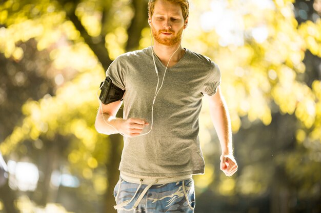 Joven corriendo en el parque de otoño