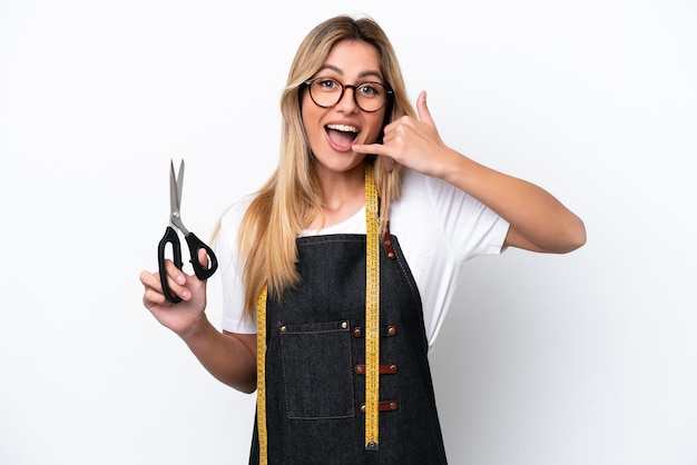 Joven costurera caucásica mujer aislada sobre fondo blanco haciendo gesto de teléfono Llámame signo de vuelta