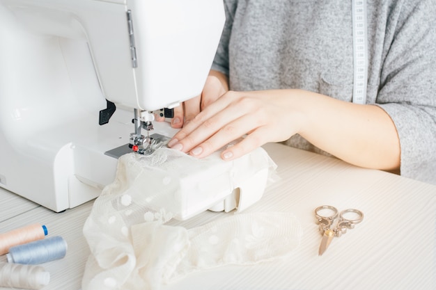 Joven costurera trabajando en la máquina de coser