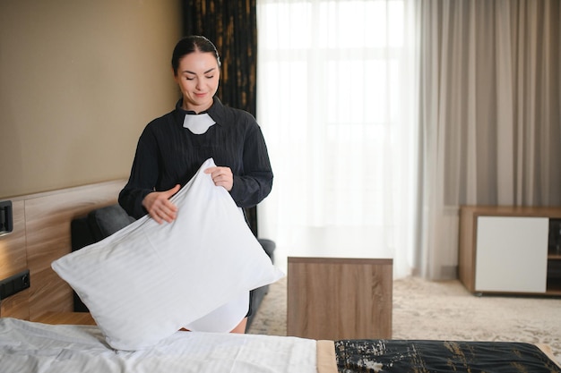 La joven criada del hotel haciendo la cama.