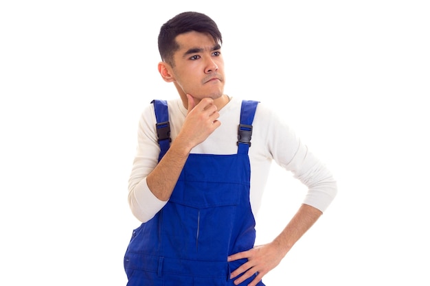 Joven cruzado con cabello oscuro vestido con camisa blanca y azul en general mirando a la distancia