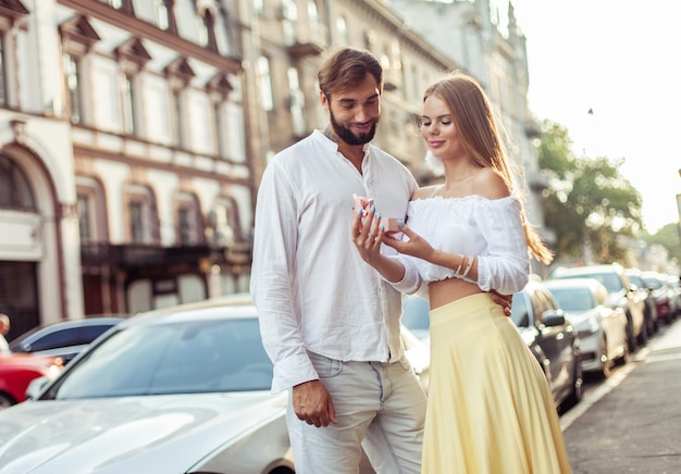 Foto un joven le da un regalo a su mujer en la ciudad una pareja enamorada un concepto romántico