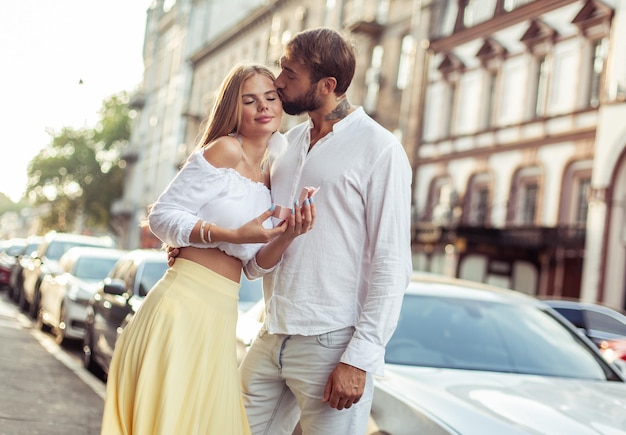 Un joven le da un regalo a su mujer en la ciudad una pareja enamorada un concepto romántico