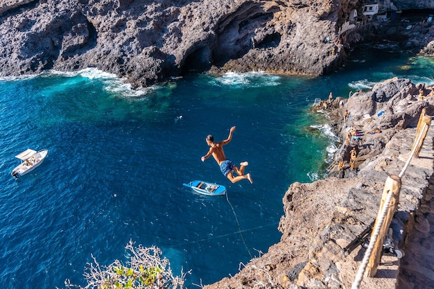 Un joven dando un salto muy alto al agua en el pueblo de Poris de Candelaria