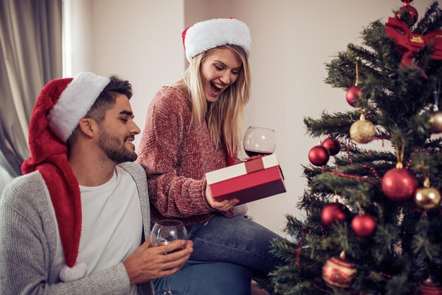 Joven dando a su novia un regalo de Navidad