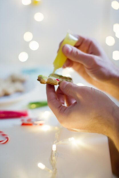 Foto joven decora galletas de navidad