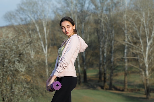 Una joven delgada atlética en ropa deportiva realiza un conjunto de ejercicios Fitness y estilo de vida saludable
