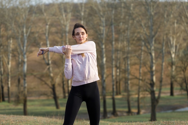 Una joven delgada atlética en ropa deportiva realiza un conjunto de ejercicios Fitness y estilo de vida saludable