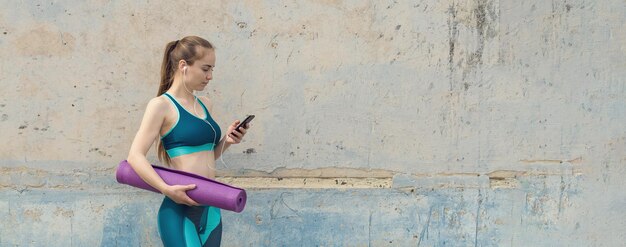 Una joven delgada atlética en ropa deportiva realiza un conjunto de ejercicios Fitness y estilo de vida saludable