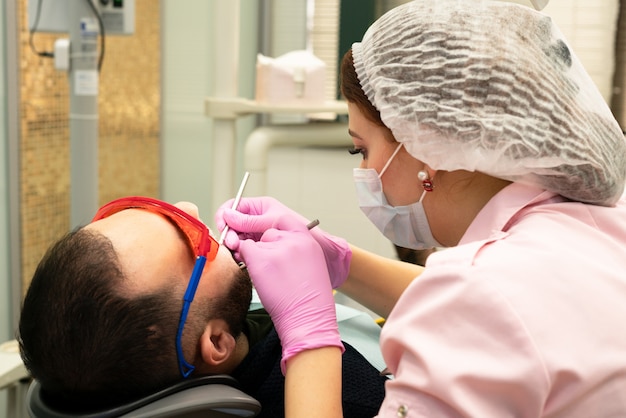 joven dentista trata a un paciente