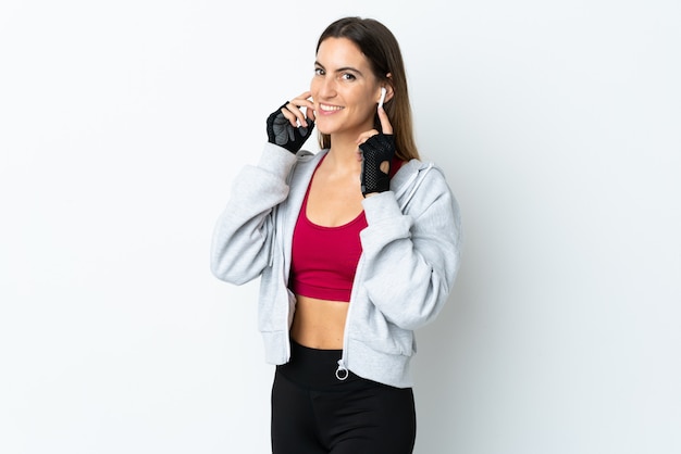 Joven deporte mujer escuchando música en la pared