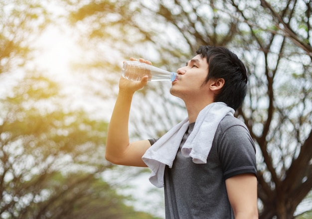 joven deportista agua potable en el parque