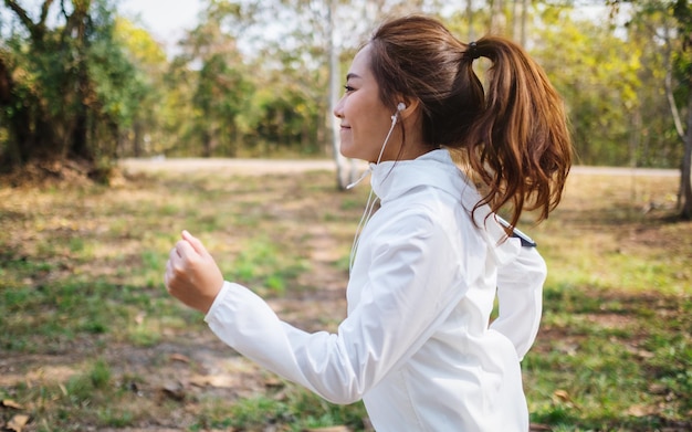 Foto una joven deportista asiática trotar en el parque de la ciudad por la mañana