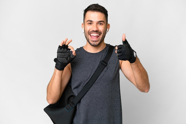 Joven deportista caucásico con bolsa deportiva sobre un fondo blanco aislado que muestra el signo de ok y el gesto del pulgar hacia arriba