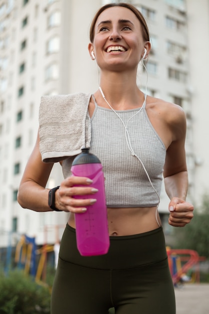 Joven deportista corriendo con rastreador de fitness en la ciudad