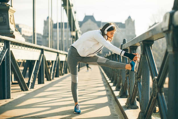 Joven deportista estirándose y preparándose para correr.