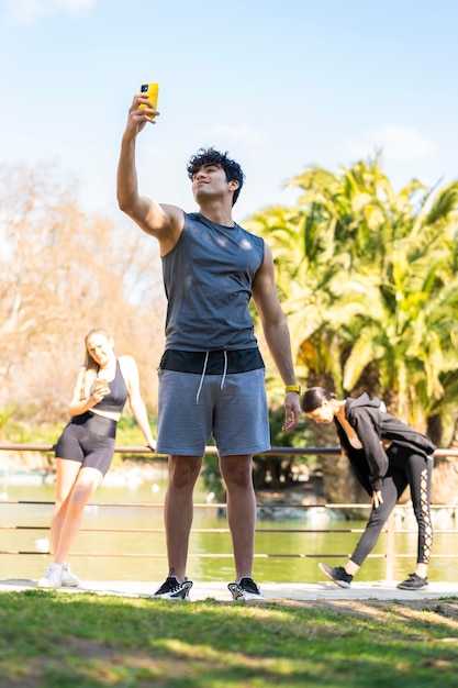 Joven deportista hace un descanso para tomar un selfie en el parque