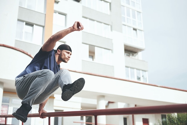 Joven deportista haciendo parkour en la ciudad.