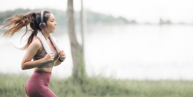 Joven deportista hermosa con auriculares funcionando