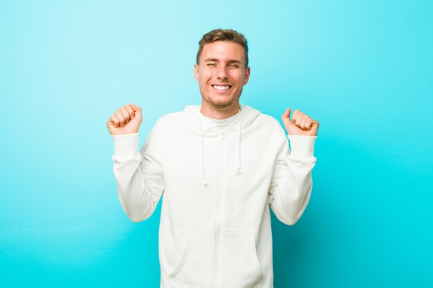 Joven deportista levantando el puño, sintiéndose feliz y exitoso