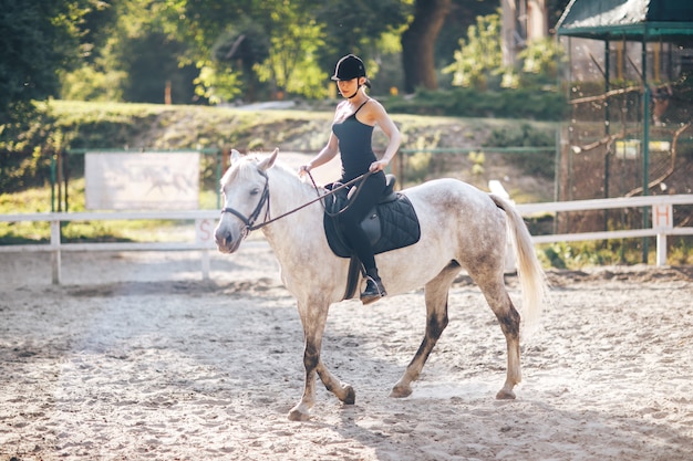 Una joven deportista monta un caballo