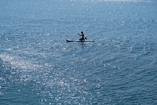 Un joven deportista con un niño navega en un sup en el mar. Concepto de estilo de vida saludable.