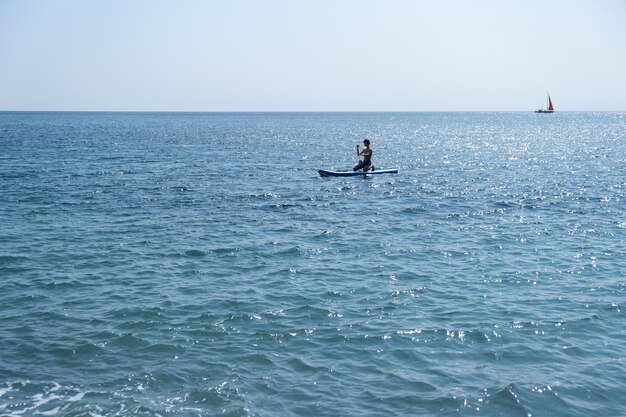 Un joven deportista con un niño navega en un sup en el mar. Concepto de estilo de vida saludable.