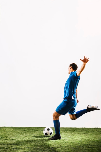 Foto joven deportista pateando la pelota con poder