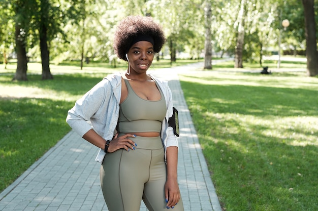 Joven deportista plus size de pie en el parque