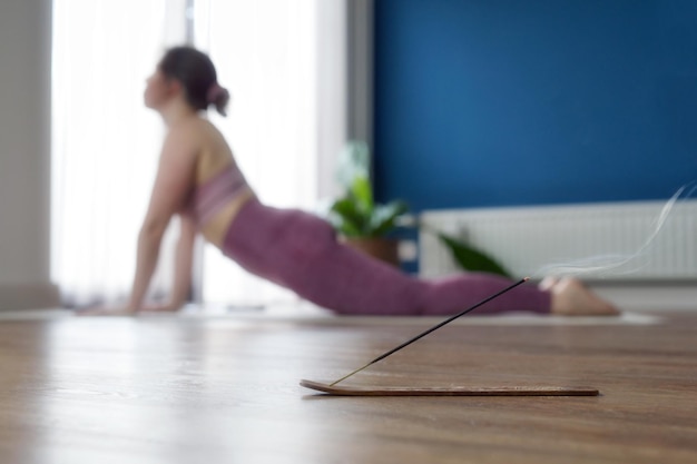 Joven deportista practicando yoga en casa haciendo ejercicio de perro boca arriba urdhva mukha shvanasana