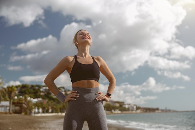 Joven deportista relajándose mientras está de pie en la playa